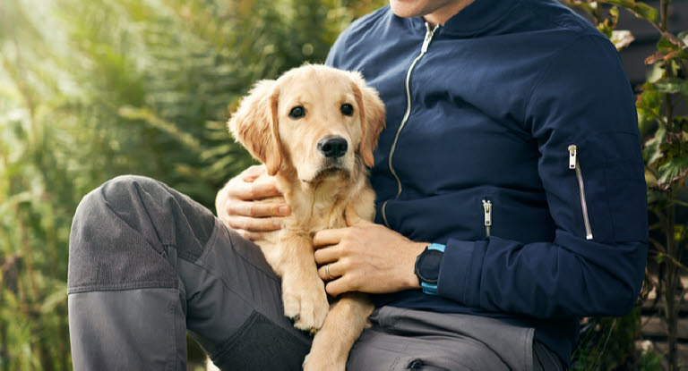 Man med hundvalp i knäet.