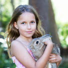 Flicka tar hand om sin kanin.