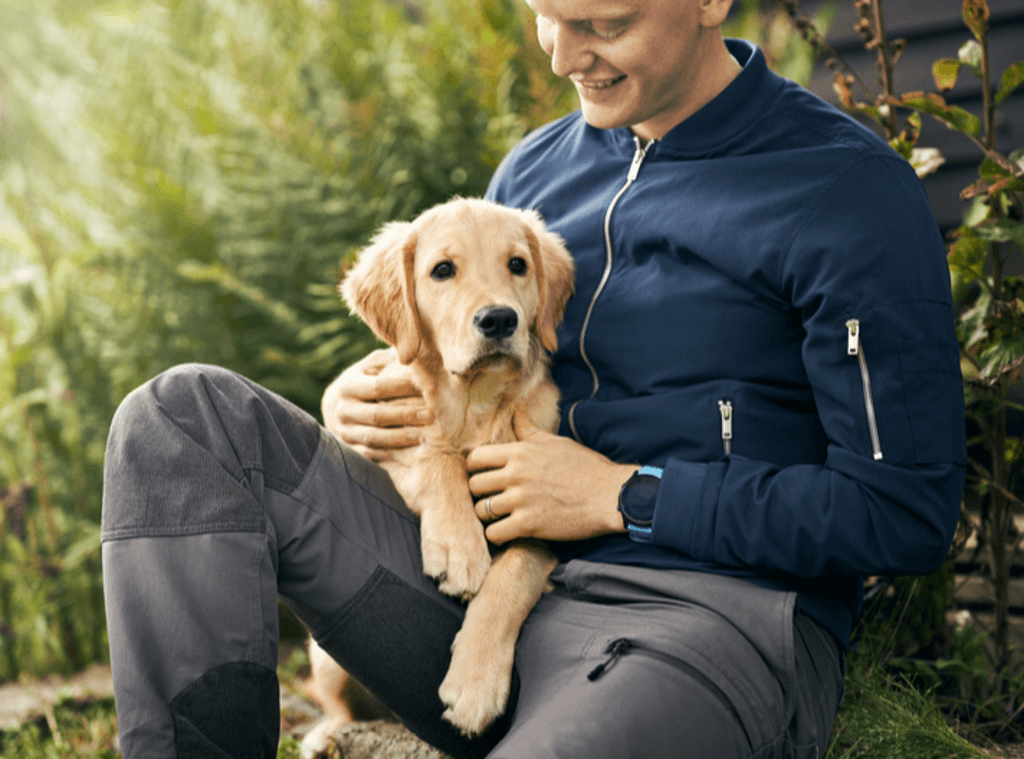 Man med hundvalp i knäet.
