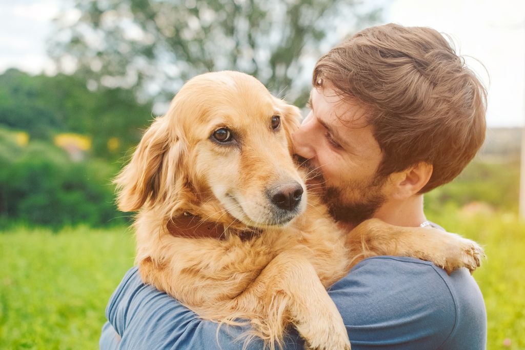 Husse som kramar om sin hund.