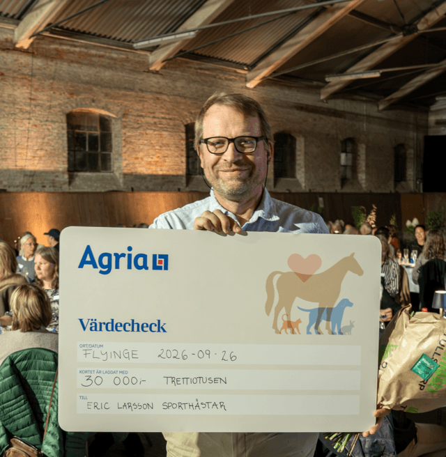 Arne Henning Larsen håller upp en prischeck från Agria på 30 000 kronor.