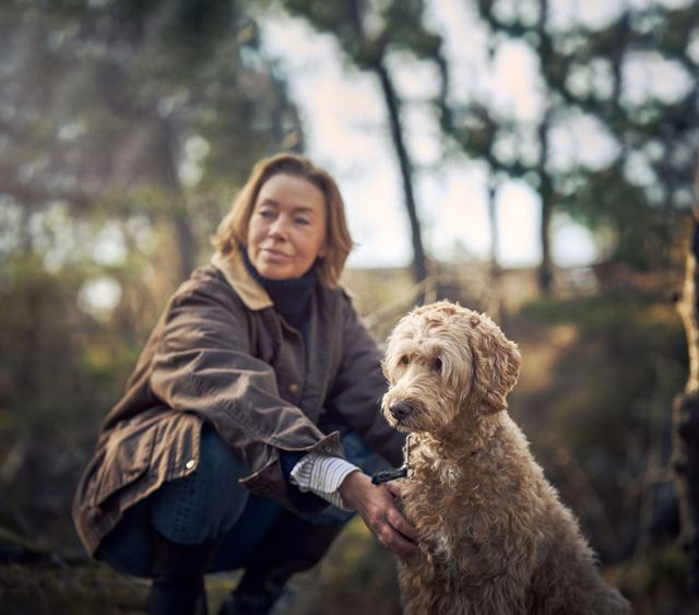 Hund och matte är ute i skogen en höstdag och sitter ner och vilar.
