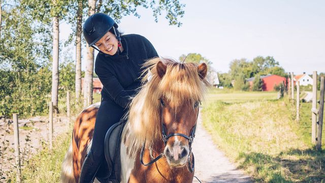 Kvinna rider på häst utomhus