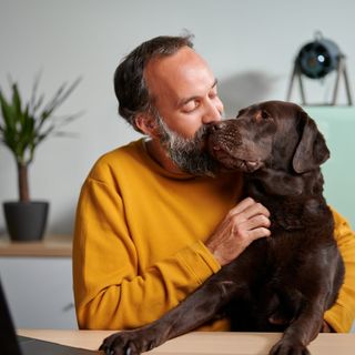 Husse och hund myser tillsammans i ett vardagsrum.