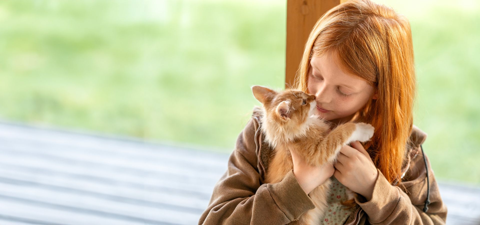 Flicka gosar med sin kattunge.