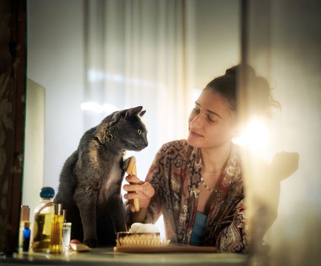 Kvinna som borstar katt.