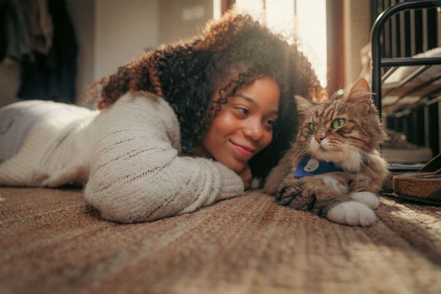 Kvinna ligger på golvet med sin katt