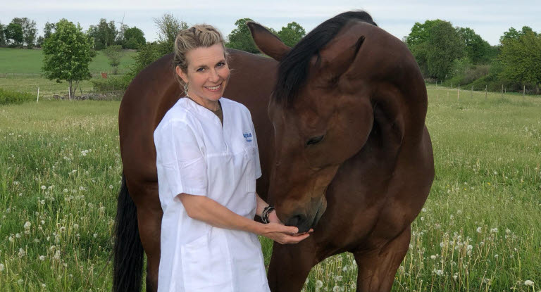 Bild på veterinär Linda Dunbäck i hage med häst.
