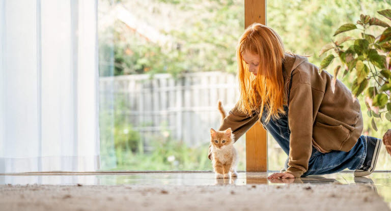 Flicka som klappar kattunge försäkrad med Agria Katt Extra.