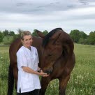 Bild på veterinär Linda Dunbäck i hage med häst.