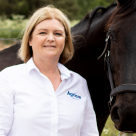 Agrias veterinär Anette Graf bredvid en brun häst.