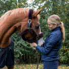 Emelie Brolin bredvid en fuxfärgad häst.